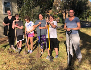 6 volunteers with shovels in front yard