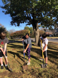 3 volunteers digging in front yard